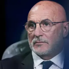 Łysy mężczyzna w okularach, z siwą brodą, w garniturze i krawacie. To trener reprezentacji Hiszpanii.