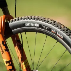 Pomarańczowy rower z amortyzatorem Fox i oponą Rekon. Czy do opony bezdętkowej można założyć dętkę? Tak, ale nie jest to zalecane.