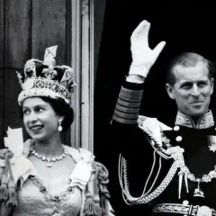 La reina Isabel II, con su corona, y el príncipe Felipe saludan tras su coronación.