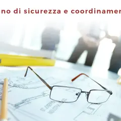 Il psc cos'è? Un piano di sicurezza e coordinamento su disegni tecnici, occhiali, matita, metro e casco.