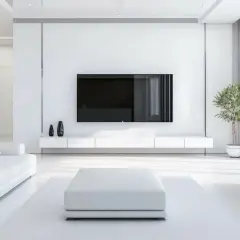 Soggiorno minimalista dominato dal colore bianco, con divano, pouf e mobile TV coordinati. Un tocco di verde da una pianta.