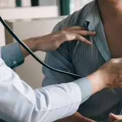 Lekarz osłuchuje pacjenta stetoskopem.