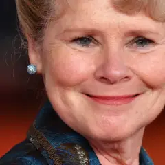 Uśmiechnięta Imelda Staunton, znana z roli Dolores Umbridge w Harry Potter, w błyszczących kolczykach.