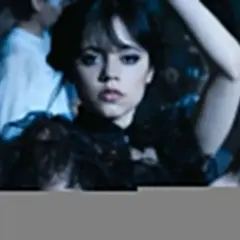 Wednesday Addams tańczy na balu, otoczona przez innych uczniów.