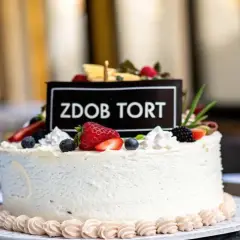 Elegancki tort dla 14 latki, ozdobiony świeżymi owocami i napisem "Zdob Tort". Idealny na wyjątkową okazję.