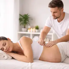 Donna incinta rilassata riceve un massaggio prenatale da un terapista esperto.