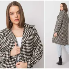 Elegancki płaszcz w klasyczną pepitkę, idealny na jesienne dni. Modelka prezentuje go z jeansami i botkami.