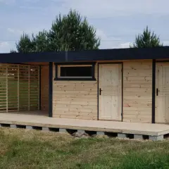 Nowy domek z tarasem na działkę, z drewnianymi drzwiami i oknem, gotowy na letnie wieczory.