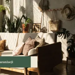Słoneczny salon boho z wygodną kanapą, mnóstwem roślin i plecionymi dodatkami.