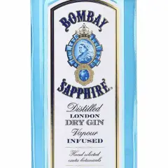 Niebieska butelka z etykietą Bombay Sapphire, na której widnieje portret królowej i napis "Distilled London Dry Gin".