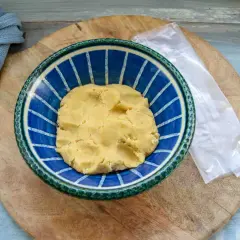 Frischer quiche teig in einer blauen Schüssel, bereit für die Zubereitung einer herzhaften Quiche.