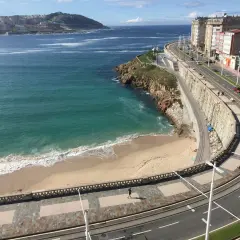 Una de las 10 mejores playas de A Coruña, con arena dorada, mar turquesa y un paseo marítimo con edificios modernos.