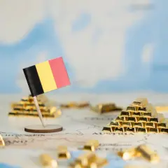 Flaga Belgii na tle mapy Europy z sztabkami złota.