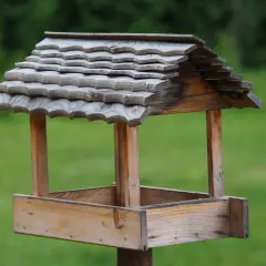 Drewniany karmnik dla ptaków diy, z dachem pokrytym łupkiem, gotowy na zimowych gości.