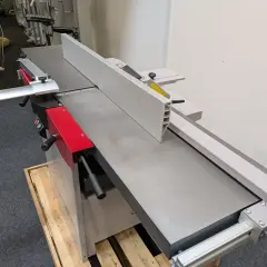 Détail d'une dégauchisseuse Hammer C3 41, machine à bois professionnelle avec son guide et ses poignées rouges.