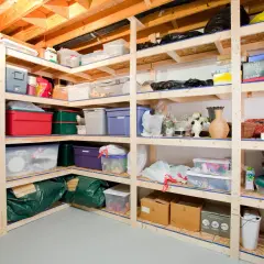 Shelving unit filled with various storage bins, boxes, and bags, showcasing practical basement storage ideas for organizing household items.