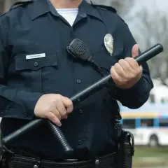 Ochroniarz z pozwoleniem na broń trzyma pałkę. Zastanawiasz się, ile zarabia ochroniarz z pozwoleniem na broń?