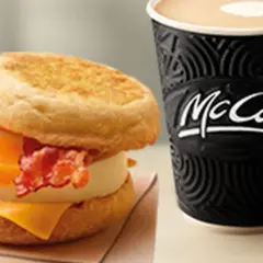 McMuffin z jajkiem, serem i bekonem obok kubka McCafe. Idealny zestaw na śniadanie.