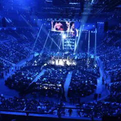 Widok z góry na arenę sportową z widownią, ringiem i ekranem.