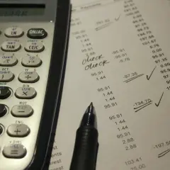 Kalkulator i dokument z danymi finansowymi, z zaznaczonymi fragmentami.