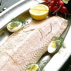 En vacker inkokt lax på ett silverfat, garnerad med ägg, citron och dill. Perfekt för en svensk sommarmåltid.