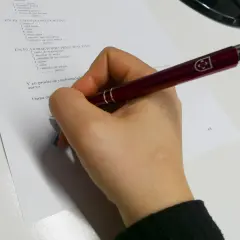 Mano con bolígrafo revisando un inventario de muebles para un contrato de alquiler, cumpliendo la ley de arrendamientos urbanos.
