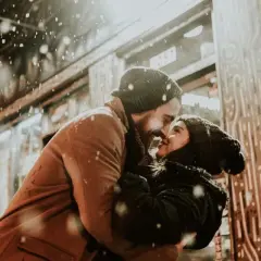 Coppia che si abbraccia sotto la neve, con lui che la guarda intensamente. Se lui non ti desidera, non ti ama.