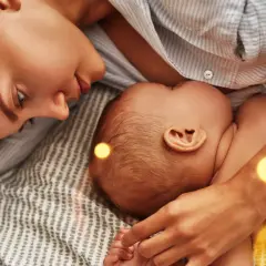 Mama czule patrzy na dziecko, które karmi piersią. Czasem pojawia się kryzys laktacyjny w 4 miesiącu, ale miłość i bliskość pomagają go pokonać.
