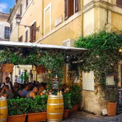 Un charmant restaurant à Rome, "Antica Osteria Rugantino", envahi par la végétation. Idéal pour savoir où manger à Rome.