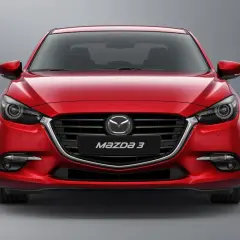 Czerwona Mazda 3 BN z przodu, z błyszczącym grillem i reflektorami.