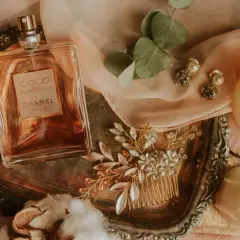 Elegancka butelka Coco Mademoiselle Chanel, biżuteria i świece. Jak sprawdzić czy perfumy są oryginalne? Zwróć uwagę na detale.