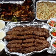 Pyszny kofta kebab z ryżem, sałatkami i sosami.