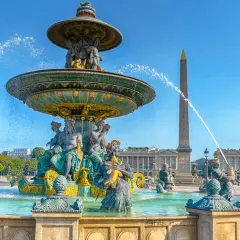 Fontaine monumentale et obélisque sur la place de la Concorde, Paris, sous un ciel bleu éclatant.