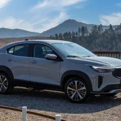 Fiat Fastback 2026 grigio metallizzato, un SUV coupé con un design audace, parcheggiato su un bel belvedere montano.