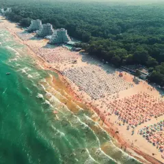 Tłok na plaży w Bułgarii. Zielone morze, złoty piasek i mnóstwo parasoli tworzą wakacyjny krajobraz.