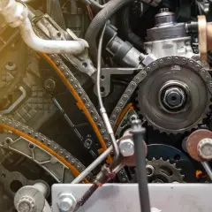 Widok mechanizmu rozrządu w silniku diesla. Zastanawiasz się, jak często wymieniać rozrząd w dieslu? Ten obraz pokazuje skomplikowany układ łańcuchów i kół zębatych.