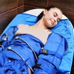 Kobieta odpoczywa podczas zabiegu 4fizjo drenaż limfatyczny. Urządzenie uciska jej ciało, poprawiając krążenie.