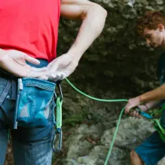 Escaladores listos para la acción, con sus manos cubiertas de magnesio piedra para un mejor agarre en la roca.