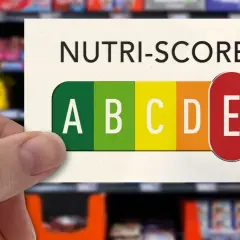 Hand hält Karte mit Nutri-Score D, das eine schlechte Bewertung für Lebensmittel darstellt.
