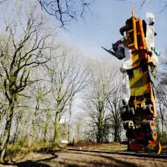 Im tony cragg skulpturenpark ragt eine bunte, auf dem Kopf stehende Konstruktion aus Metall und Stoff in den Himmel, umgeben von kahlen Bäumen.