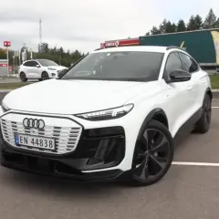 Białe Audi Q6 e-tron na parkingu. Zastanawiasz się nad audi q6 e-tron cena? Sprawdź, czy warto!