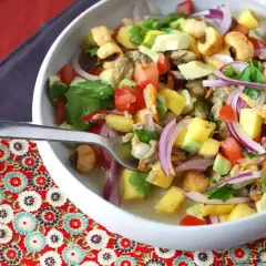 Delicioso ceviche de berberechos con mango, aguacate, tomate y cebolla morada. Una explosión de sabor fresco y vibrante.