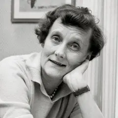 En ung Astrid Lindgren lutar sig mot sin hand, med ett drömmande uttryck.