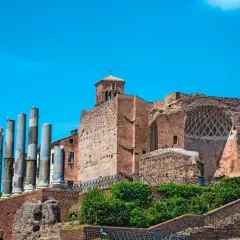 Vestiges de la Domus Aurea, avec ses colonnes antiques et ses ruines de briques sous un ciel bleu éclatant.