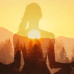Silhouette di donna in meditazione con tramonto e foreste. Un'immagine che ispira a come ridurre lo stress con la natura.