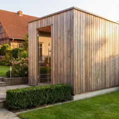 Moderne Gartensauna aus Holz mit Glasfront, perfekt für das eigene Wellness-Erlebnis im Garten. Ein Traum für alle, die eine Gartensauna selber bauen möchten.