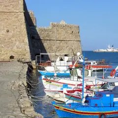 Port w Heraklionie, Kreta. Wrzesień, idealna temperatura na rejs. W tle twierdza, łodzie rybackie i dźwig portowy.