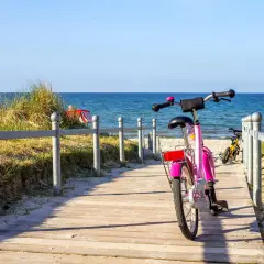 Różowy rower czeka na ścieżce przy plaży. Idealne miejsce na odkrywanie tras rowerowych Władysławowo.