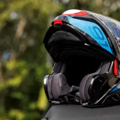 Kask motocyklowy RPHA 91 w kolorze czarnym z niebieskimi i białymi akcentami, gotowy na kolejną podróż.
