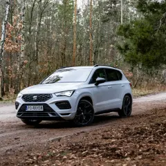 Biały Seat Ateca na leśnej drodze, gotowy na przygodę.